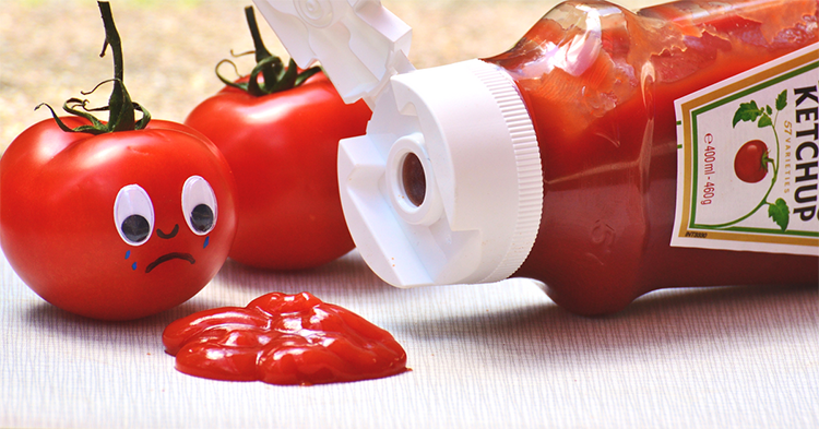 Tomato with a sad face looking at ketchup