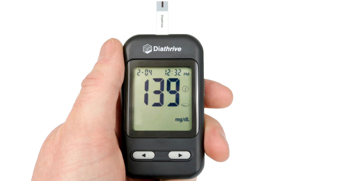 Hand holding a Diathrive glucometer