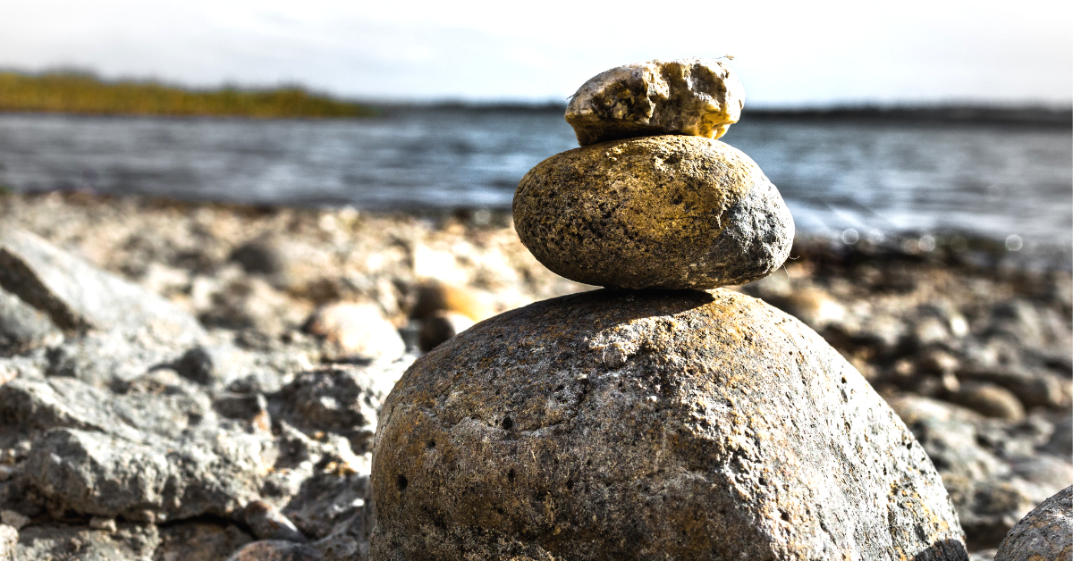 A stack of balanced rocks on a lake shore