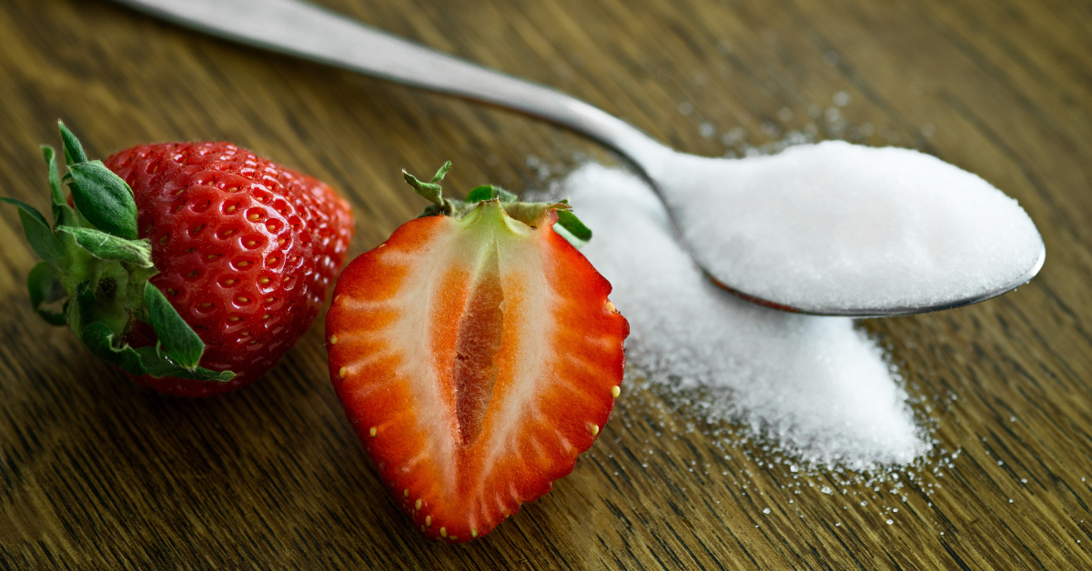 Strawberries and a spoon of sweetener on a wooden table