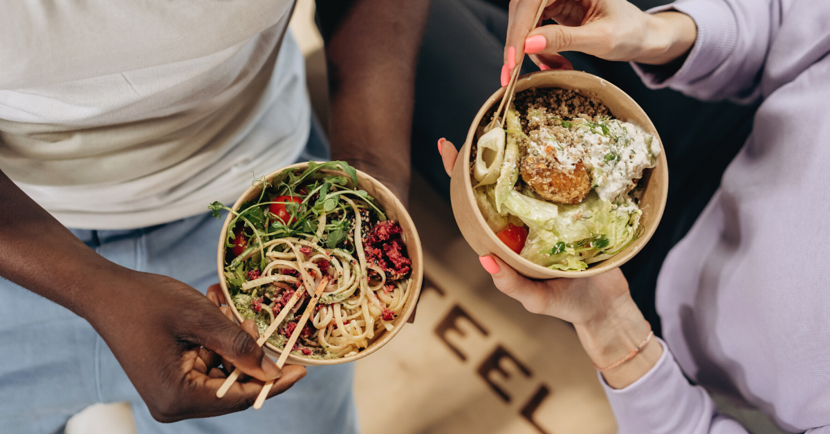 Two people with bowls of healthy food