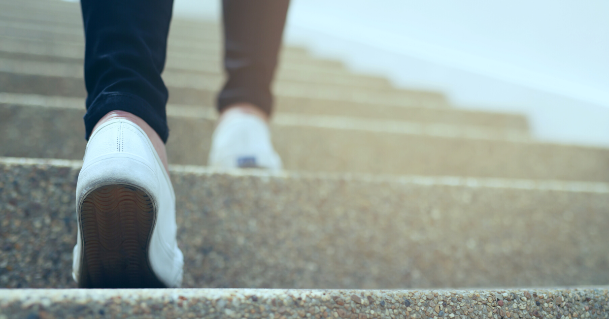 Woman walking up concrete stairs outside