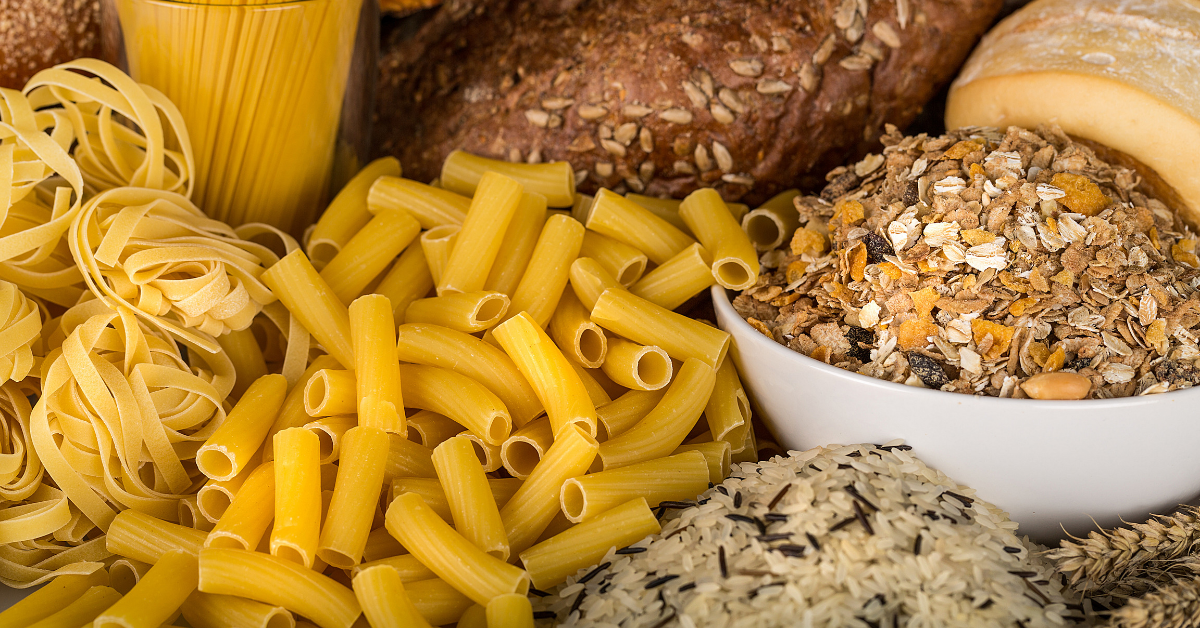 Grains, bread, and uncooked pasta laid out on a table