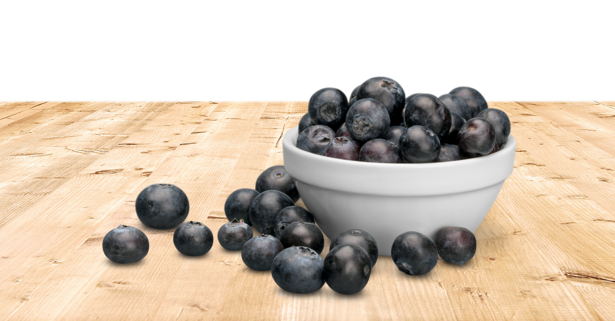 A bowl of blueberries on a wooden table