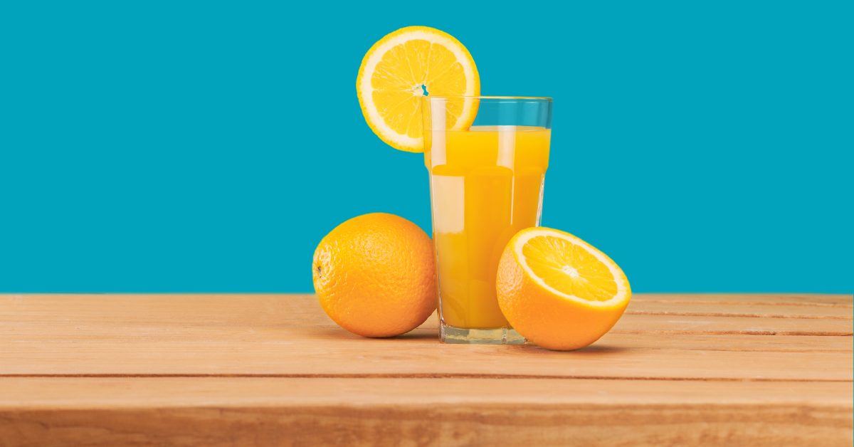 Oranges and a glass of orange juice on wooden table