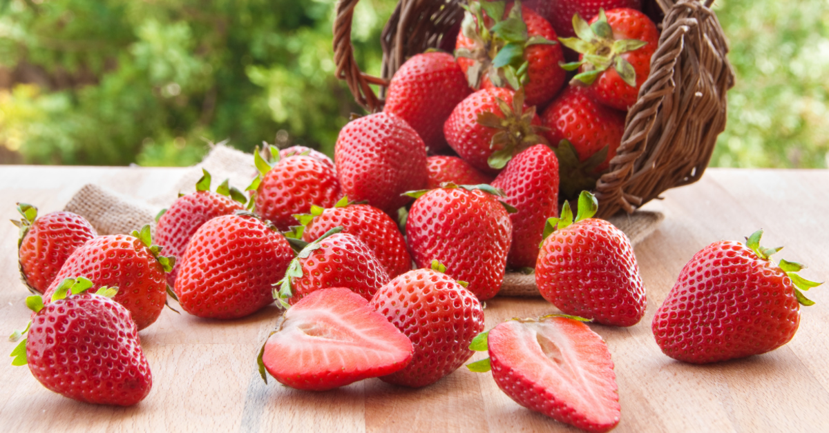 Basket of strawberries pouring out on a table