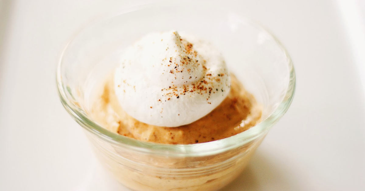 Pumpkin Mousse with a dollop of whipped cream in a glass dish
