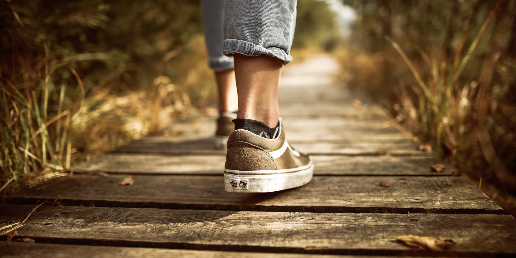 Close up of feet walking on a wooden pathway